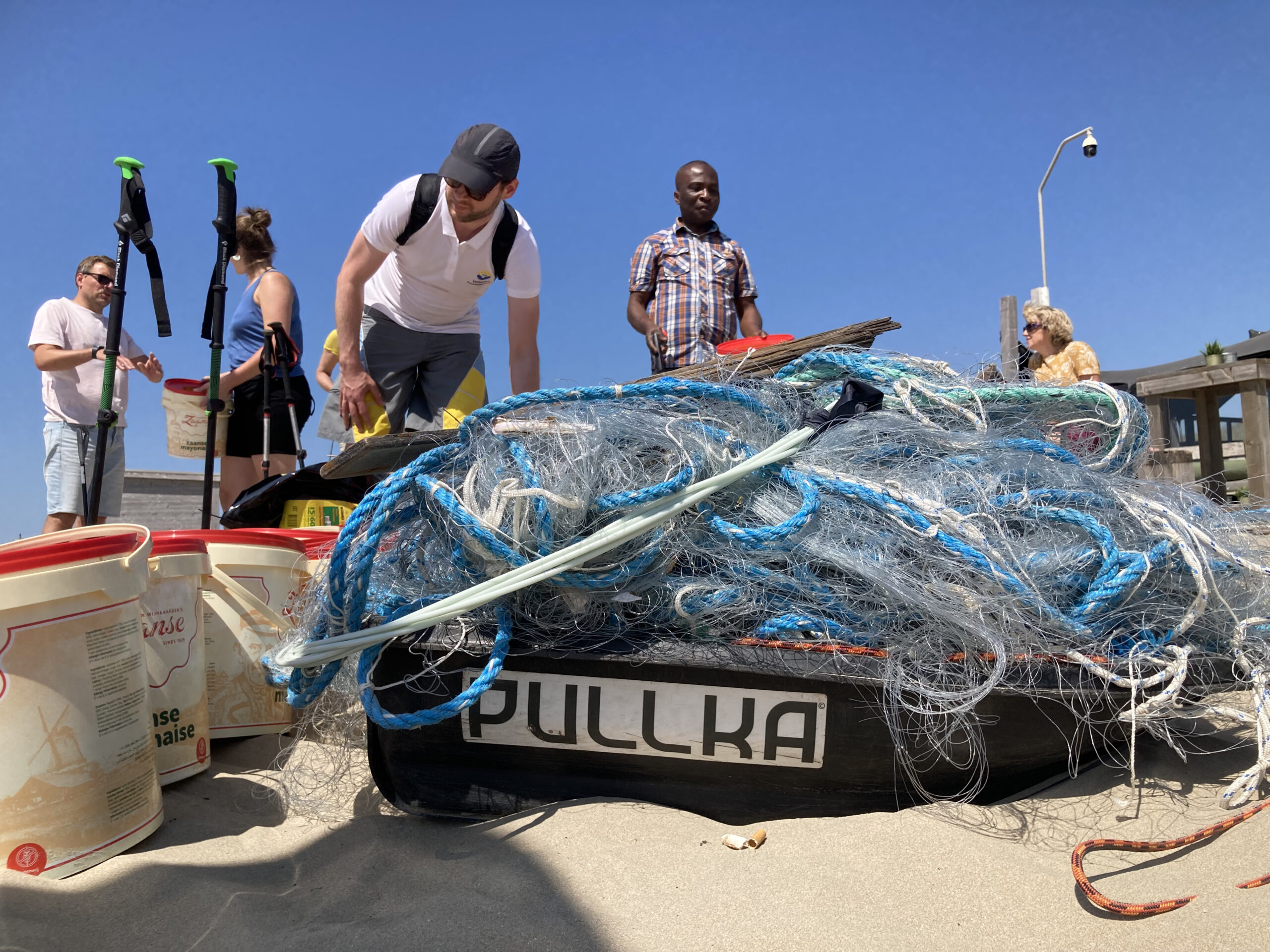 team dat strand schoonmaakt tijdens teamuitje
